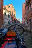 Gondola sailing in the canals of Venice photo