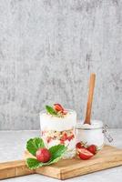 granola or yogurt with strawberry in glass, fresh berries and jar photo