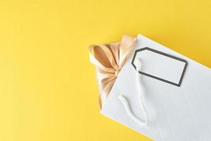 bolsa de compras blanca con caja de regalo sobre fondo azul, vista superior foto