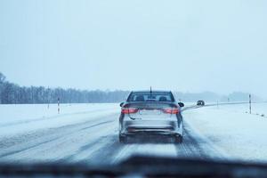 Back view of car on snowy winter road photo