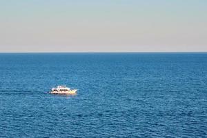 barco blanco en el mar o el océano contra la puesta de sol foto