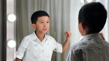 little asian boy talking to mirror video