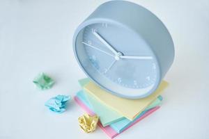 Gray round alarm clock and colorful sticky notes on a white background photo
