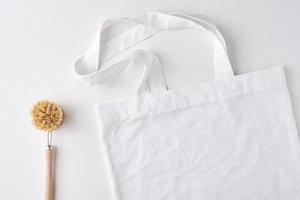 shopping bag with copy space and wooden brush on a white background, top view photo