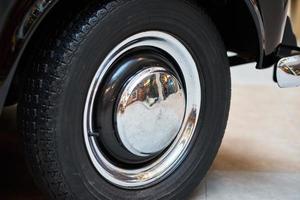 Vintage wheel with protector of retro car, closeup photo