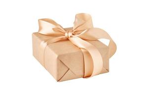 close up gift box in craft paper with golden ribbon isolated photo