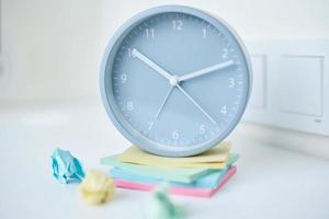 Gray round alarm clock and colorful sticky notes on a white background photo
