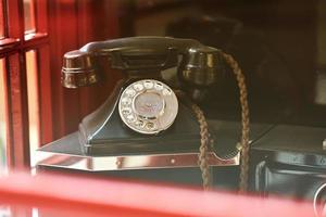 teléfono retro vintage en una cabina roja británica tradicional de cerca foto