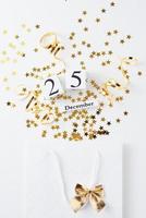 Shopping bag with festive confetti on white background photo