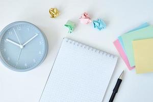 Gray round alarm clock colorful sticky notes and notebook photo