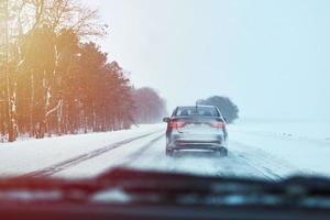 Back view of car on snowy winter road photo