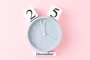 Christmas background with alarm clock on pink background photo