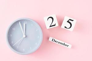 Christmas background with alarm clock on pink background photo