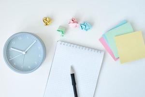 Gray round alarm clock colorful sticky notes and notebook photo