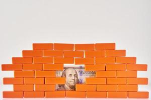 Broken brick wall with a dollar bill in hole. Business and finance concepte photo
