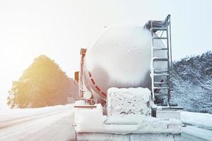 Truck with cargo tank on slippery snow winter road outside the city photo