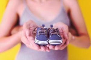 couple holding newborn baby shoes photo