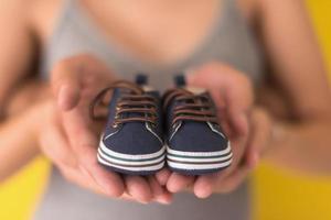 couple holding newborn baby shoes photo