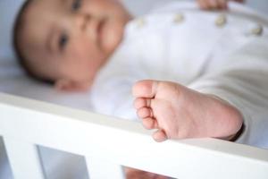 The baby's leg is close-up, the child is lying in bed. Baby care, Healthy sleep, skin irritation, massage photo