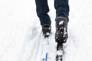 Feet of a skier in ski boots on cross-country skis. Walking in the snow, winter sports, healthy lifestyle. Close-up, copyspace photo