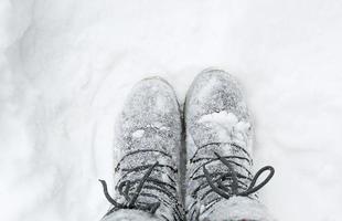 las botas en los cordones están cubiertas de nieve. invierno, nevadas, frío, zapatos de lana afieltrada, protección contra heladas, resistencia a las heladas. vida en el pueblo, núcleo de cabaña, autenticidad. primer plano, espacio de copia foto