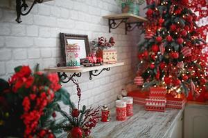 regalos en cajas de primer plano bajo un árbol de navidad con decoración roja y blanca en una sala de estar blanca. año nuevo, estilo europeo, decoración de cocina. espacio para texto, enfoque selectivo en el coche foto