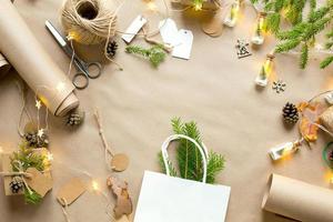 Gift Package for Christmas and new year in eco-friendly materials kraft paper, live fir branches, cones, twine. Tags with mock up, natural decor, hand made, DIY. Copy space. Flatly, background photo