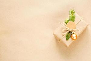 caja de regalo para navidad y año nuevo en materiales ecológicos papel kraf, ramas de abeto vivas, conos, hilo. etiquetas con maqueta, decoración natural, hechas a mano, bricolaje. planamente, fondo, marco, minimalismo foto