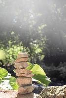 A stack of zen rocks are in the forest with trees in the background photo