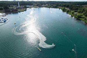 bellas imágenes de la cámara de drones aéreos del lago y parque willen que se encuentra en milton keynes, inglaterra. la gente está disfrutando en el lago en un caluroso día soleado de verano foto