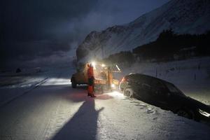 coche siendo remolcado después de un accidente en una tormenta de nieve foto