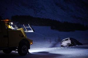 coche siendo remolcado después de un accidente en una tormenta de nieve foto