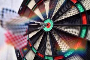 Darts arrow hitting in the target center photo