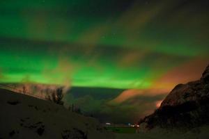 Aurora borealis Green northern lights above mountains photo