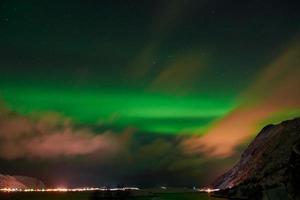 Aurora borealis Green northern lights above mountains photo