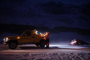 coche siendo remolcado después de un accidente en una tormenta de nieve foto