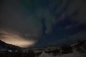 Aurora borealis Green northern lights above mountains photo