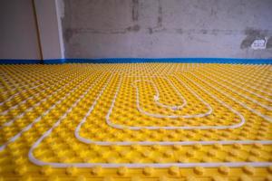 yellow underfloor heating installation with white pipes photo