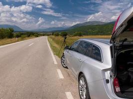 cámara dslr profesional en un trípode en una carretera asfaltada en un hermoso paisaje foto