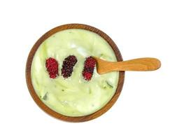 mezcla de yogur sabor a té verde en polvo con nata de coco dutchie y moras fruta en tazón de madera aislado sobre fondo blanco foto