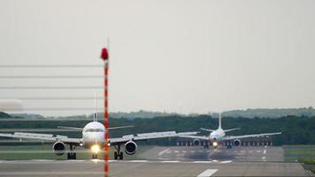 dusseldorf, alemania 22 de julio de 2017 - almasria universal airlines airbus 320 su tce rodando después del aterrizaje, y turkish airlines airbus a330 en la pista de giro librea retro. aeropuerto de dusseldorf, alemania video