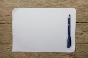 A sheet of paper with a pen on wooden office desk photo