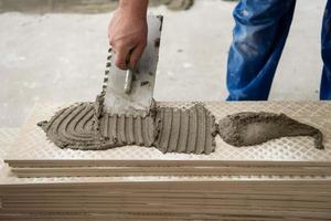 worker installing the ceramic wood effect tiles on the floor photo