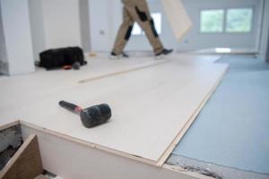 Worker Installing New Laminated Wooden Floor photo