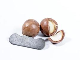 Open Macadamia nut by tool on background photo