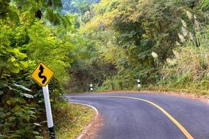 Curvy road sign on mountain photo