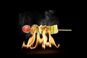 skewer of mixed meat and vegetables on the grill photo