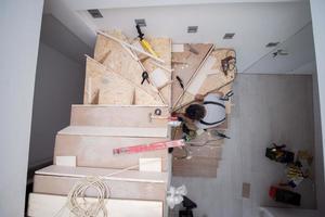 carpenter installing wooden stairs photo