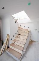 work in progress on stylish interior with wooden stairs photo