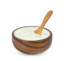 yogur con nata de coco dutche en tazón de madera y cuchara aislado sobre fondo blanco, incluye trazado de recorte foto